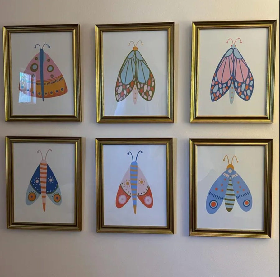 Customer photo of a six-print Design South colorful moth gallery wall in gold frames.
