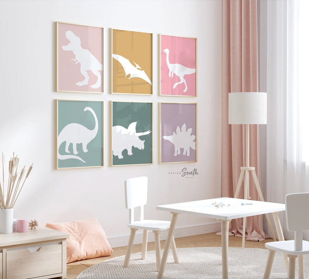 Adorable dinosaur art prints designed for a little girls room, featuring playful dinosaurs in shades of pink, teal, and purple. These vibrant and fun dinosaur illustrations are perfect for adding a touch of adventure and charm to toddler wall decor. Ideal for a girl&#39;s nursery, bedroom, or playroom, these art prints create a whimsical and colorful space. Perfect for girls who love dinosaurs, this wall decor adds personality and joy to any room setting, making it a delightful addition to her s