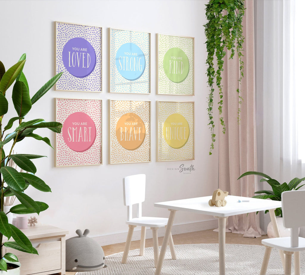 Set of 6 inspirational wall art prints for kids featuring rainbow-colored circles with modern speckled designs. Each print includes a positive affirmation: you are loved, you are kind, you are brave, you are smart, you are strong. Designed in purple, blue, green, pink, orange, and yellow for a vibrant and trendy playroom or nursery. This uplifting art set is perfect for encouraging confidence and positivity in babies, toddlers, or young children’s spaces.