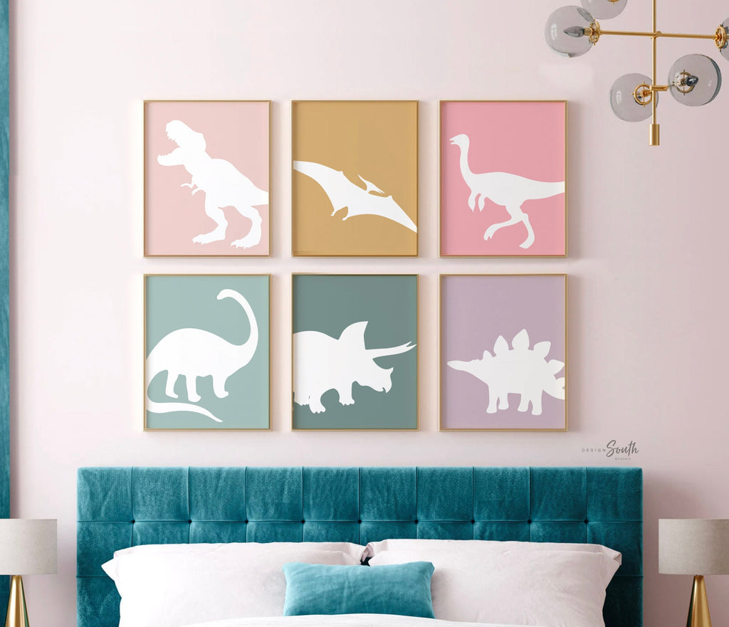 Adorable dinosaur art prints designed for a little girls room, featuring playful dinosaurs in shades of pink, teal, and purple. These vibrant and fun dinosaur illustrations are perfect for adding a touch of adventure and charm to toddler wall decor. Ideal for a girl&#39;s nursery, bedroom, or playroom, these art prints create a whimsical and colorful space. Perfect for girls who love dinosaurs, this wall decor adds personality and joy to any room setting, making it a delightful addition to her s