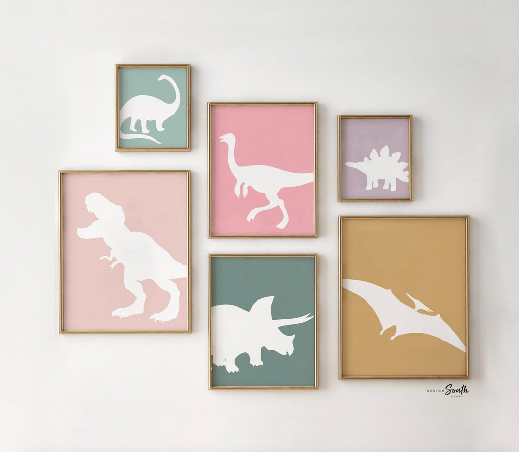 Adorable dinosaur art prints designed for a little girls room, featuring playful dinosaurs in shades of pink, teal, and purple. These vibrant and fun dinosaur illustrations are perfect for adding a touch of adventure and charm to toddler wall decor. Ideal for a girl&#39;s nursery, bedroom, or playroom, these art prints create a whimsical and colorful space. Perfect for girls who love dinosaurs, this wall decor adds personality and joy to any room setting, making it a delightful addition to her s