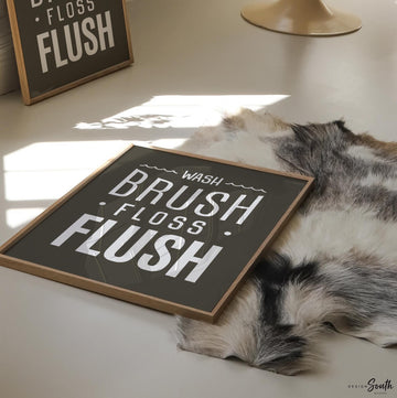Brown and white bathroom wall art featuring the phrases &quot;wash, brush, floss, flush.&quot; Perfect for a boy’s bathroom or a gender-neutral space, this print brings a simple yet charming touch to any kids’ or guest bathroom. Great for encouraging healthy habits, this design blends well with brown and white decor themes, creating a clean, stylish look that suits both boys’ and girls’ bathrooms.