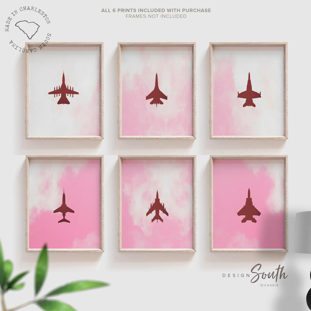 Set of 6 pink airplane art prints perfect for girls&#39; baby or toddler nursery decor. Features edgy aviation-themed designs with fighter jet silhouettes in soft pinks, combining military aircraft with a feminine twist. Ideal for a unique kids&#39; room or aviation lover&#39;s space, this collection offers stylish and modern wall art that blends playful charm with a bold, edgy feel. A distinctive addition to any nursery or playroom decor.