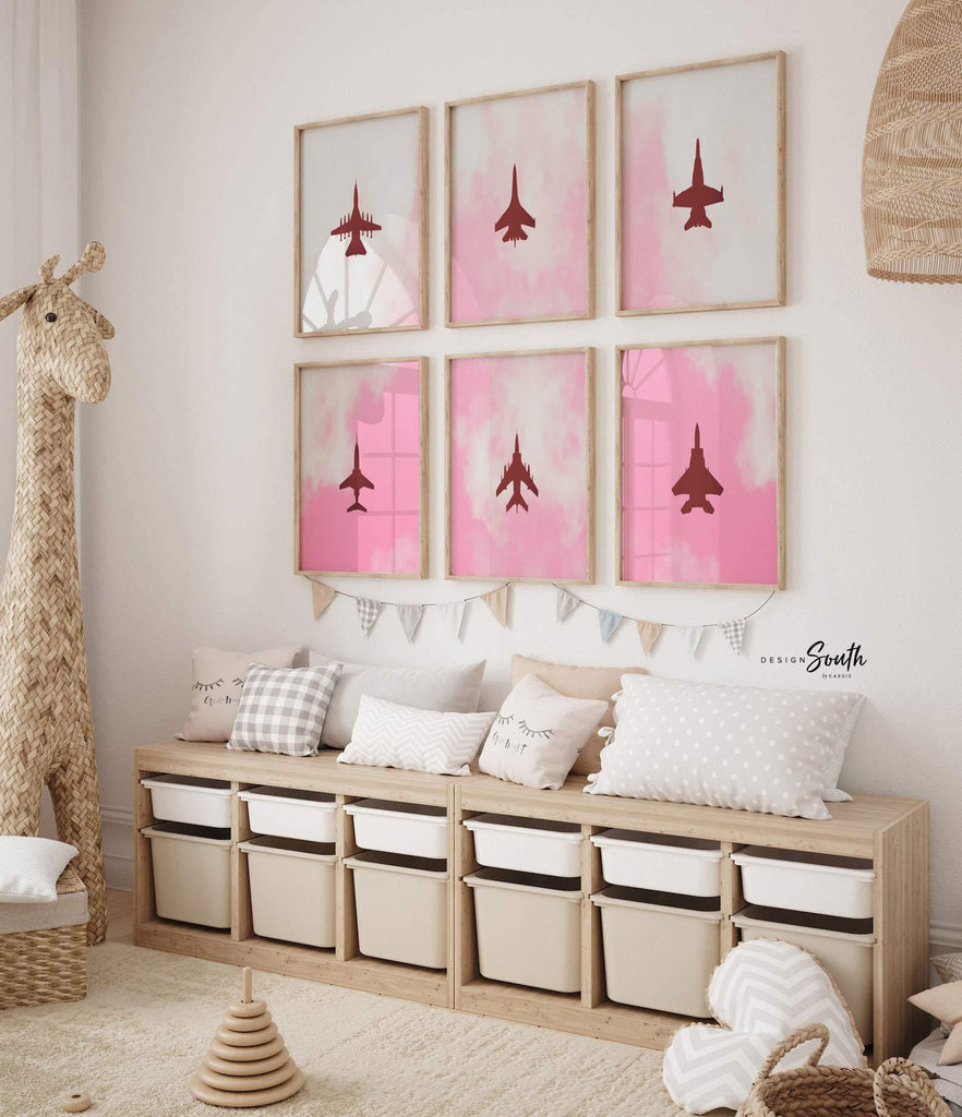 Set of 6 pink airplane art prints perfect for girls&#39; baby or toddler nursery decor. Features edgy aviation-themed designs with fighter jet silhouettes in soft pinks, combining military aircraft with a feminine twist. Ideal for a unique kids&#39; room or aviation lover&#39;s space, this collection offers stylish and modern wall art that blends playful charm with a bold, edgy feel. A distinctive addition to any nursery or playroom decor.