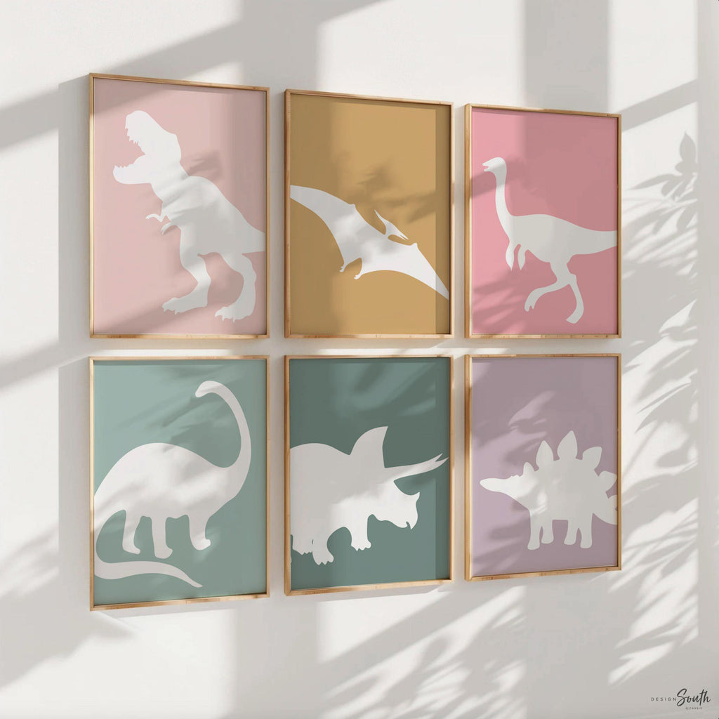 Adorable dinosaur art prints designed for a little girls room, featuring playful dinosaurs in shades of pink, teal, and purple. These vibrant and fun dinosaur illustrations are perfect for adding a touch of adventure and charm to toddler wall decor. Ideal for a girl&#39;s nursery, bedroom, or playroom, these art prints create a whimsical and colorful space. Perfect for girls who love dinosaurs, this wall decor adds personality and joy to any room setting, making it a delightful addition to her s