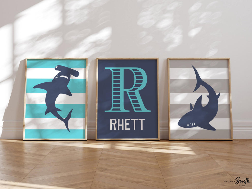 Blue gray shark-themed wall art for a toddler&#39;s room or kids&#39; bedroom. Features a friendly shark design perfect for shark-loving boys. Ideal for a personalized kids&#39; decor, this print includes a monogram or name customization option. Adds a playful, aquatic touch to any boy&#39;s room or nursery and makes a thoughtful gift for a baby shower or birthday. Modern, ocean-inspired design fits any shark theme room and complements existing sea life or ocean art decor.