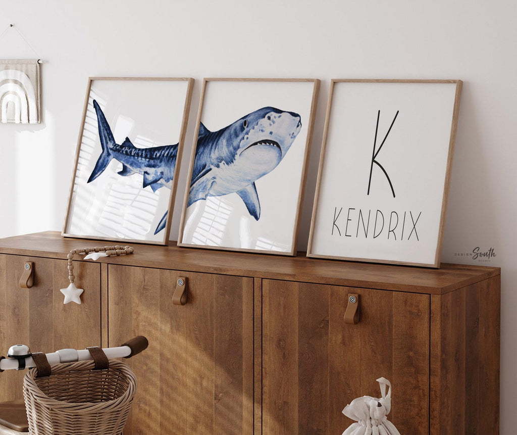 Set of shark-themed nursery wall art prints featuring a personalized boys name. Perfect for a baby boy’s room or ocean-themed nursery, this playful and modern artwork adds a fun touch to boys&#39; bedrooms or toddler spaces. Includes watercolor-style shark illustrations and bold text, ideal for a shark lover’s room or under-the-sea decor. A great gift for baby showers, birthdays, or parents creating a shark or marine life theme for their little one.