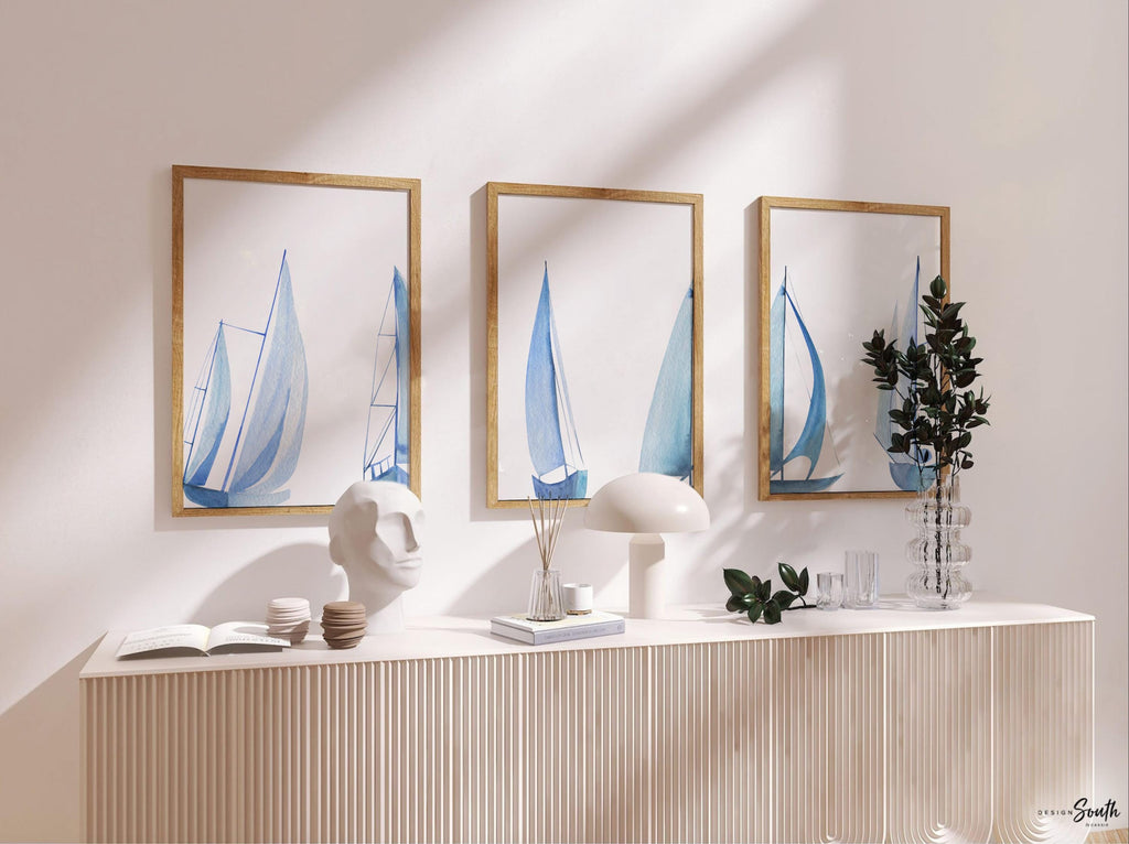 Set of 3 coastal sailboat art prints featuring watercolor paintings of sailboats on the ocean and lake. Nautical wall decor perfect for a beach house, lake house, coastal bathroom, or ocean-themed nursery. These prints showcase soft, serene colors with a calming seaside feel, ideal for summer home decor or a relaxing wall art set. Great gift for coastal lovers or sailing enthusiasts. Unframed prints available in multiple sizes for easy display and framing.