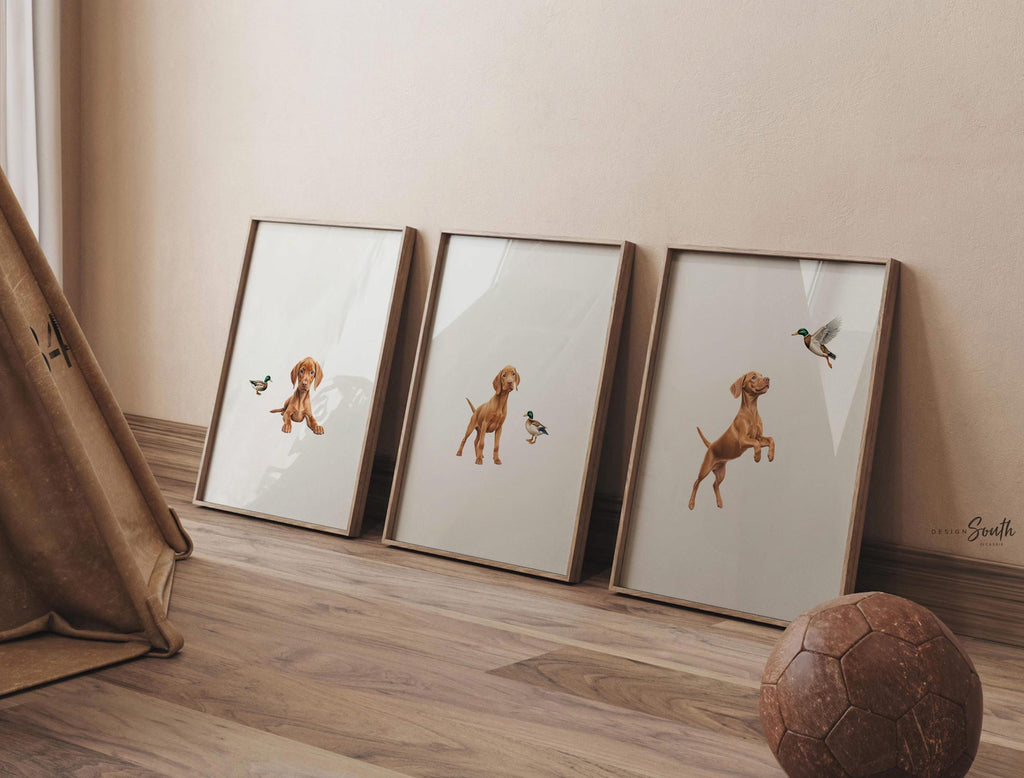 Set of 3 nursery art prints featuring Hungarian vizsla puppies accented with mallard duck birds. Designed in a soft, clean, and modern style, this sweet wall art set is perfect for a baby boy&#39;s nursery or toddler bedroom. The gentle color palette and simple composition create a calming and adorable atmosphere, ideal for dog lovers and parents looking to add a personalized, heartwarming touch to their child’s space.