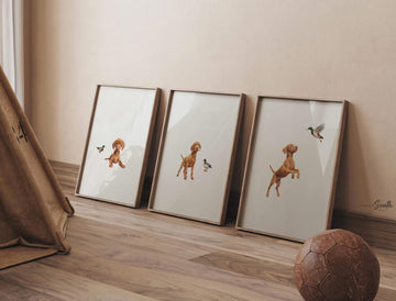 Set of 3 nursery art prints featuring Hungarian vizsla puppies accented with mallard duck birds. Designed in a soft, clean, and modern style, this sweet wall art set is perfect for a baby boy&#39;s nursery or toddler bedroom. The gentle color palette and simple composition create a calming and adorable atmosphere, ideal for dog lovers and parents looking to add a personalized, heartwarming touch to their child’s space.