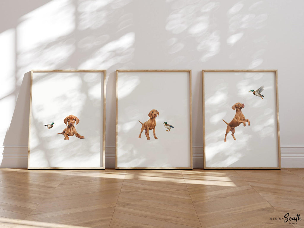 Set of 3 nursery art prints featuring Hungarian vizsla puppies accented with mallard duck birds. Designed in a soft, clean, and modern style, this sweet wall art set is perfect for a baby boy&#39;s nursery or toddler bedroom. The gentle color palette and simple composition create a calming and adorable atmosphere, ideal for dog lovers and parents looking to add a personalized, heartwarming touch to their child’s space.