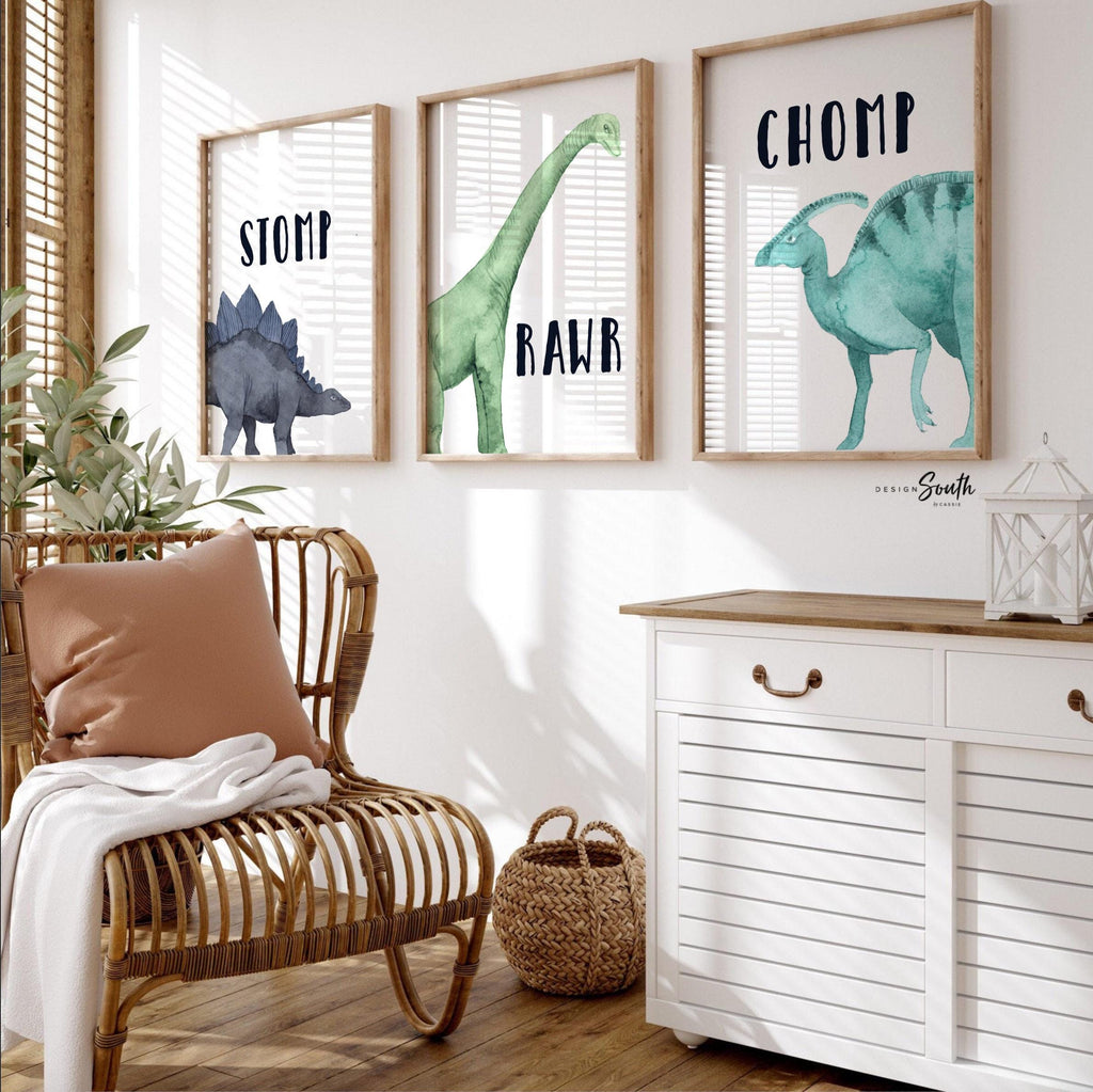 Watercolor dinosaur wall art set of 3 featuring a brachiosaurus, stegosaurus, and parasaurolophus in navy blue, green, and teal tones. Each print includes fun dinosaur-themed words: “Stomp,” “Roar,” and “Chomp,” making it perfect for a kids’ bedroom, playroom, or dinosaur-themed nursery. This playful and colorful artwork set adds a whimsical, prehistoric touch to any child’s space and makes a great gift for dino-loving toddlers or new parents decorating a gender-neutral nursery.
