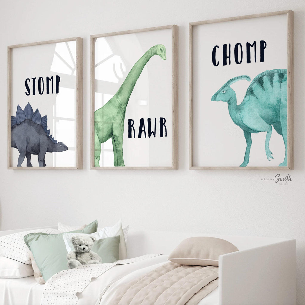 Watercolor dinosaur wall art set of 3 featuring a brachiosaurus, stegosaurus, and parasaurolophus in navy blue, green, and teal tones. Each print includes fun dinosaur-themed words: “Stomp,” “Roar,” and “Chomp,” making it perfect for a kids’ bedroom, playroom, or dinosaur-themed nursery. This playful and colorful artwork set adds a whimsical, prehistoric touch to any child’s space and makes a great gift for dino-loving toddlers or new parents decorating a gender-neutral nursery.