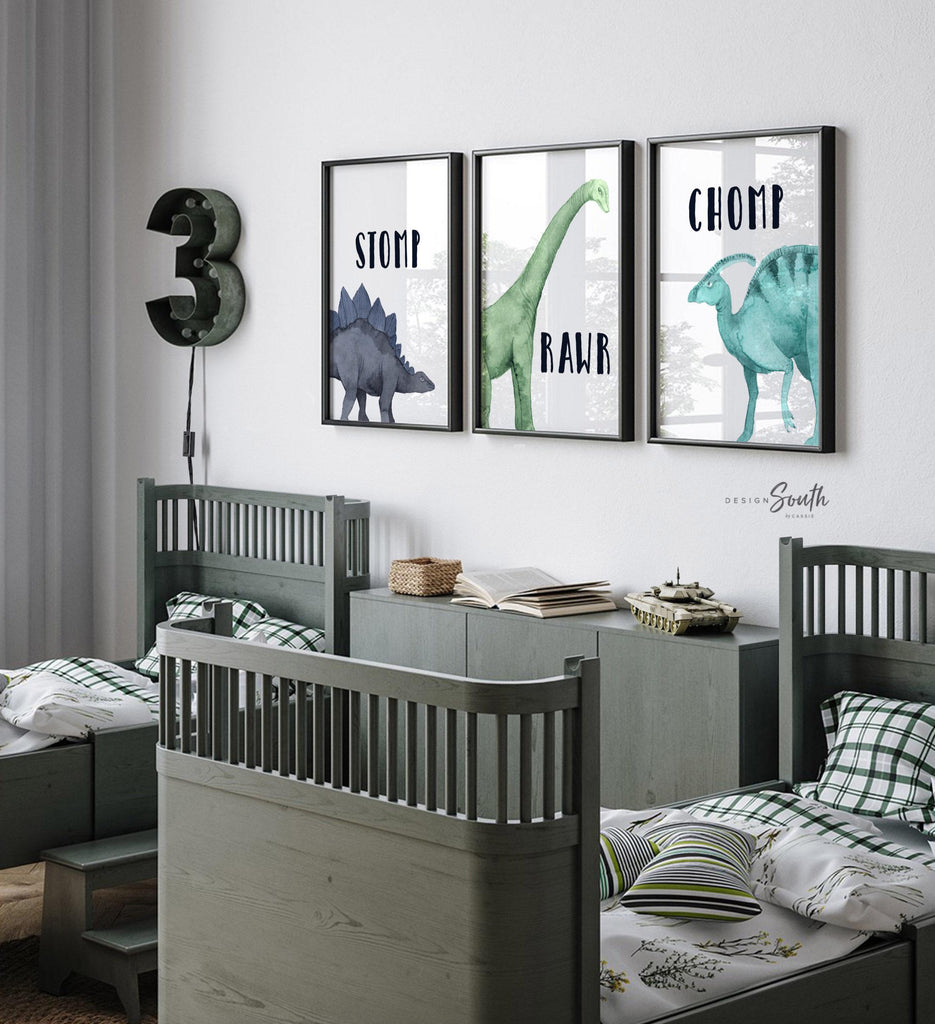 Watercolor dinosaur wall art set of 3 featuring a brachiosaurus, stegosaurus, and parasaurolophus in navy blue, green, and teal tones. Each print includes fun dinosaur-themed words: “Stomp,” “Roar,” and “Chomp,” making it perfect for a kids’ bedroom, playroom, or dinosaur-themed nursery. This playful and colorful artwork set adds a whimsical, prehistoric touch to any child’s space and makes a great gift for dino-loving toddlers or new parents decorating a gender-neutral nursery.
