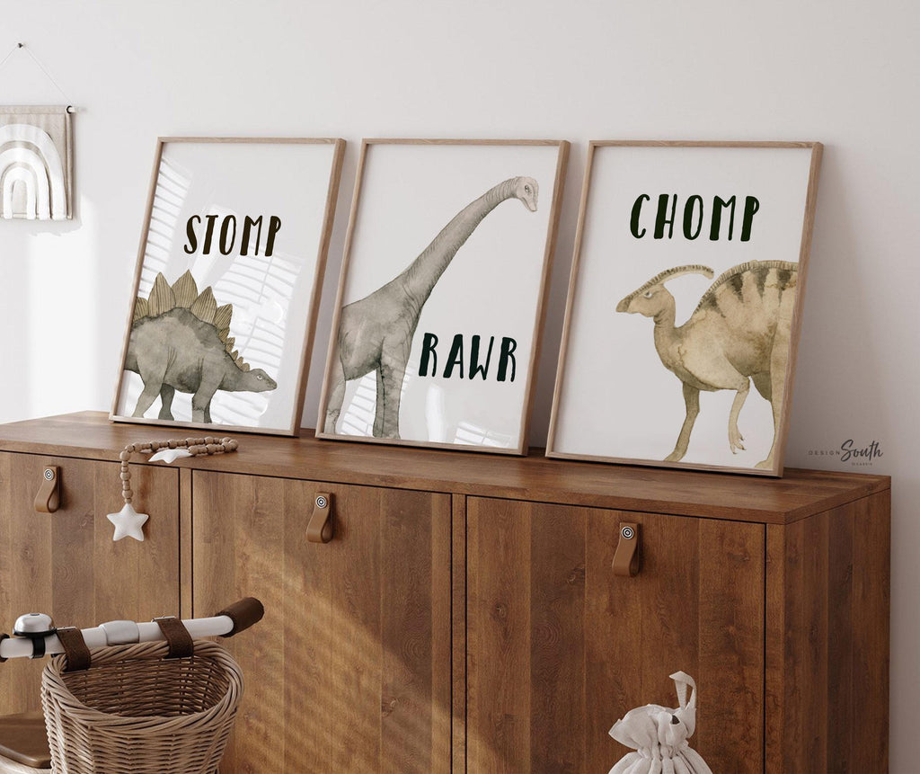 Watercolor dinosaur wall art set of 3 featuring a brachiosaurus, stegosaurus, and parasaurolophus in neutral earthy tones. Each print includes fun dinosaur-themed words: “Stomp,” “Roar,” and “Chomp,” making it perfect for a kids’ bedroom, playroom, or dinosaur-themed nursery. This playful and colorful artwork set adds a whimsical, prehistoric touch to any child’s space and makes a great gift for dino-loving toddlers or new parents decorating a gender-neutral nursery.