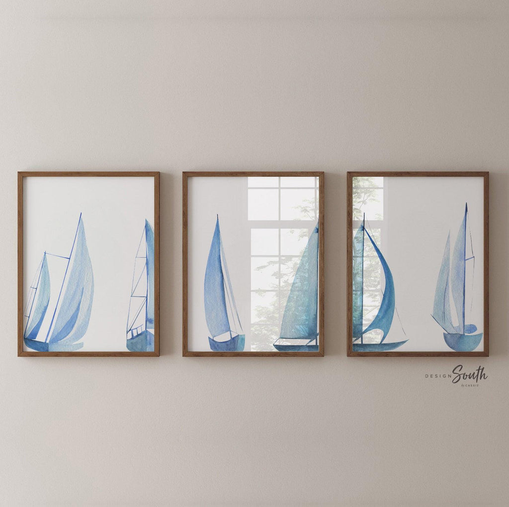 Set of 3 coastal sailboat art prints featuring watercolor paintings of sailboats on the ocean and lake. Nautical wall decor perfect for a beach house, lake house, coastal bathroom, or ocean-themed nursery. These prints showcase soft, serene colors with a calming seaside feel, ideal for summer home decor or a relaxing wall art set. Great gift for coastal lovers or sailing enthusiasts. Unframed prints available in multiple sizes for easy display and framing.