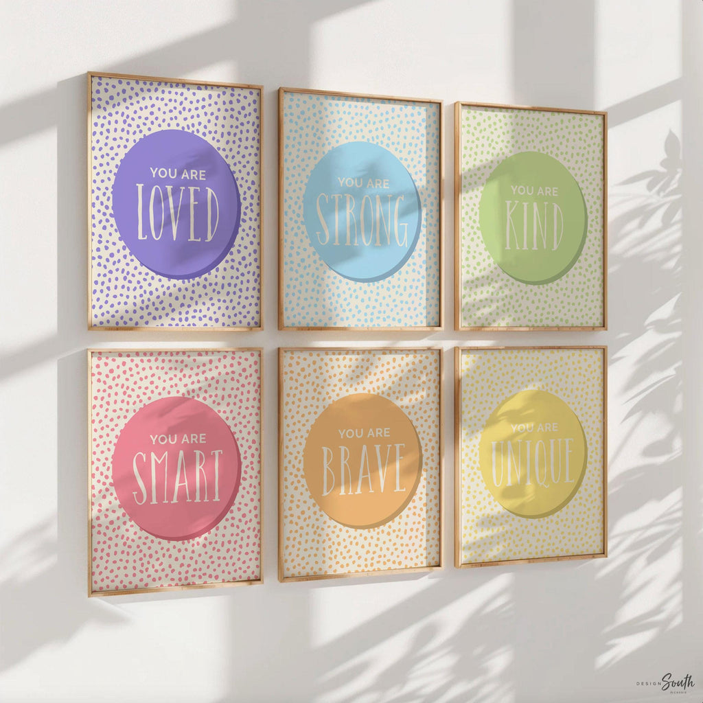 xSet of 6 inspirational wall art prints for kids featuring rainbow-colored circles with modern speckled designs. Each print includes a positive affirmation: you are loved, you are kind, you are brave, you are smart, you are strong. Designed in purple, blue, green, pink, orange, and yellow for a vibrant and trendy playroom or nursery. This uplifting art set is perfect for encouraging confidence and positivity in babies, toddlers, or young children’s spaces.
