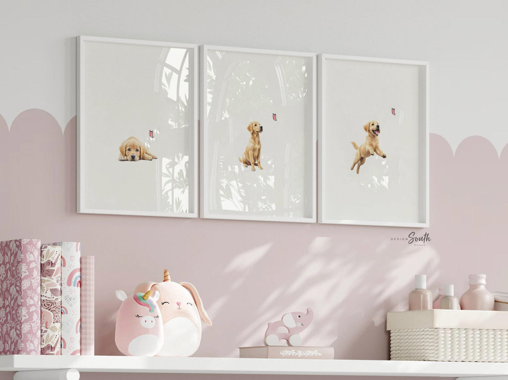 Set of 3 nursery art prints featuring golden retriever puppies playfully chasing pink butterflies. Designed in a soft, clean, and modern style, this sweet wall art set is perfect for a baby girl&#39;s nursery or toddler bedroom. The gentle color palette and simple composition create a calming and adorable atmosphere, ideal for dog lovers and parents looking to add a personalized, heartwarming touch to their child’s space.