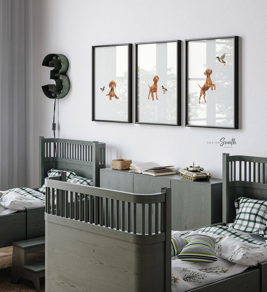 Set of 3 nursery art prints featuring Hungarian vizsla puppies accented with mallard duck birds. Designed in a soft, clean, and modern style, this sweet wall art set is perfect for a baby boy&#39;s nursery or toddler bedroom. The gentle color palette and simple composition create a calming and adorable atmosphere, ideal for dog lovers and parents looking to add a personalized, heartwarming touch to their child’s space.