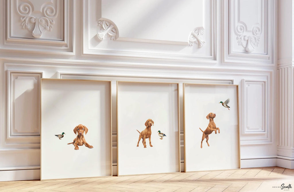 Set of 3 nursery art prints featuring Hungarian vizsla puppies accented with mallard duck birds. Designed in a soft, clean, and modern style, this sweet wall art set is perfect for a baby boy&#39;s nursery or toddler bedroom. The gentle color palette and simple composition create a calming and adorable atmosphere, ideal for dog lovers and parents looking to add a personalized, heartwarming touch to their child’s space.